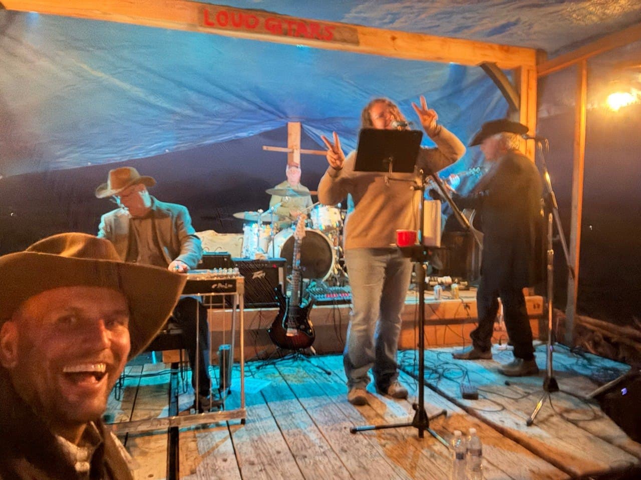 Silver Lining Band, a local band, playing live on the Loud Guitars stage at the Cadillac Wanch under blue tent lighting