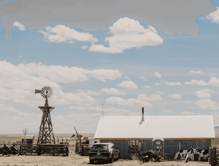 Eva's Bunk House with vintage windmills and ranch character set against the wide-open Wet Mountain Valley backdrop