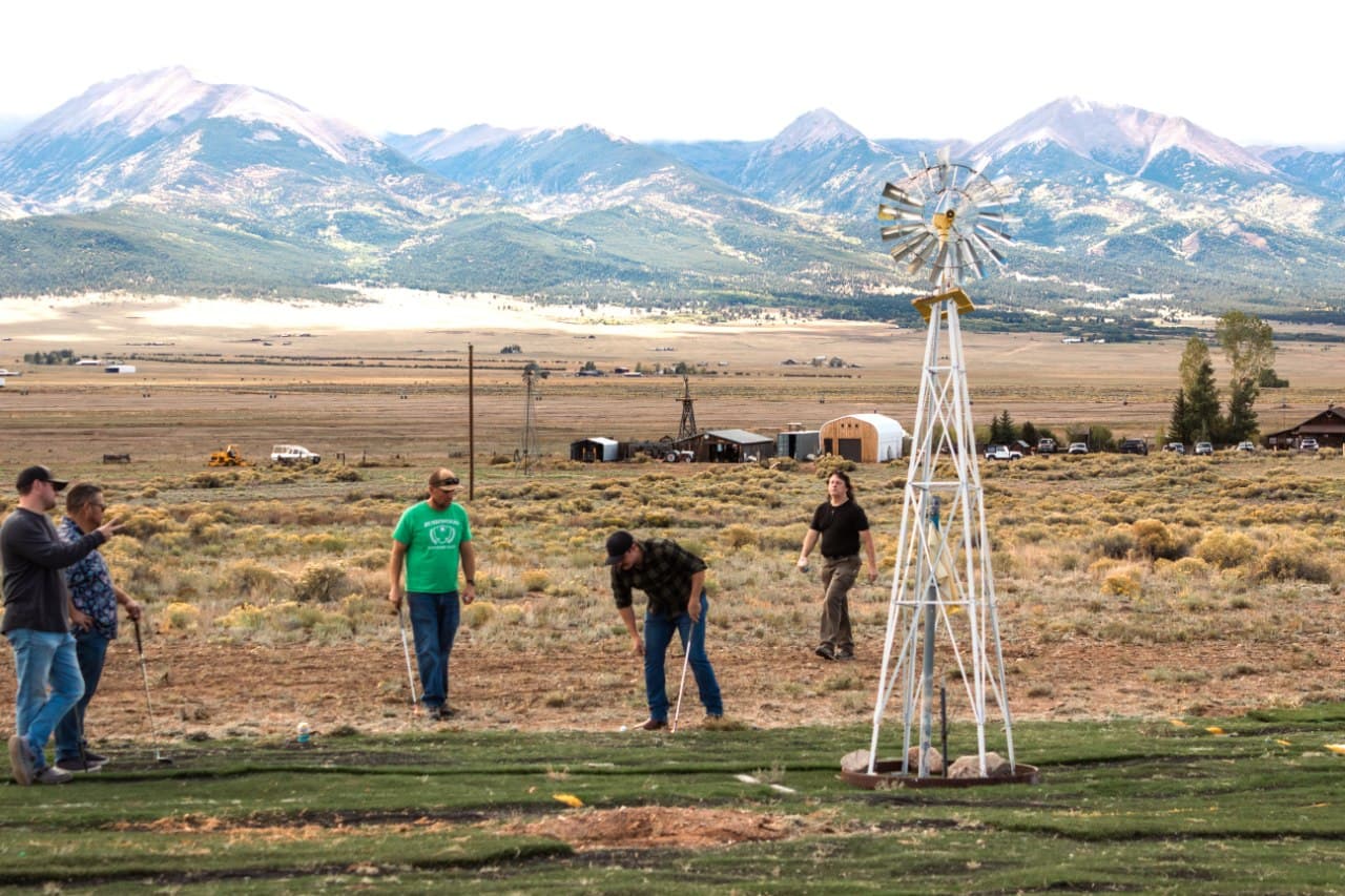 Group putting at the windmill green with the full Sangre de Cristo mountain range behind