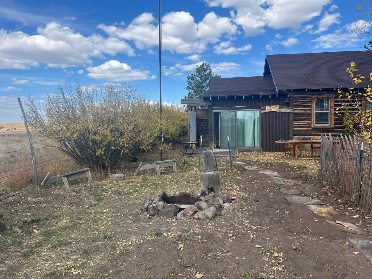 The outdoor shower and fire pit attached to Loud Guitars — dual-purpose, shared with the Wellness Center