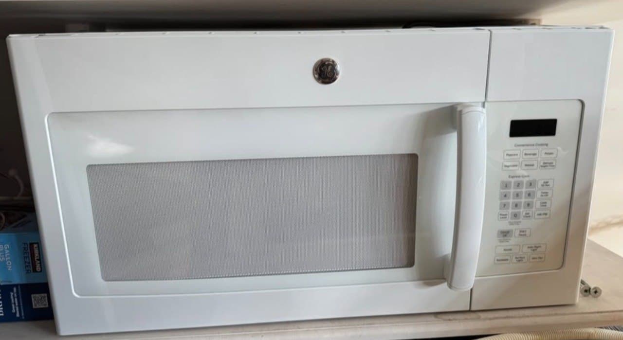 GE over-the-range microwave front view showing control panel during pickup