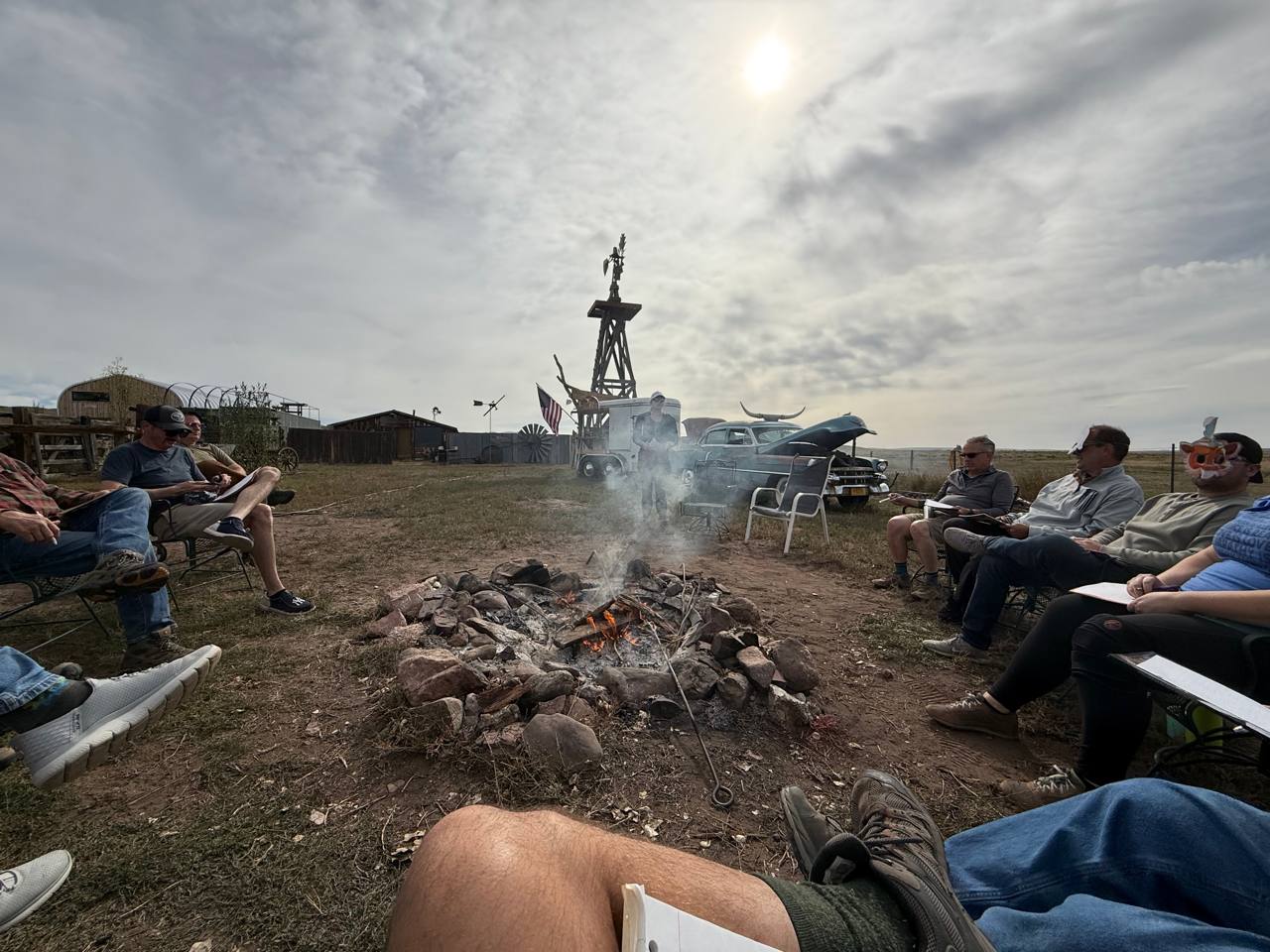 Business leaders with notepads around the fire at Turkey Toe Ranch